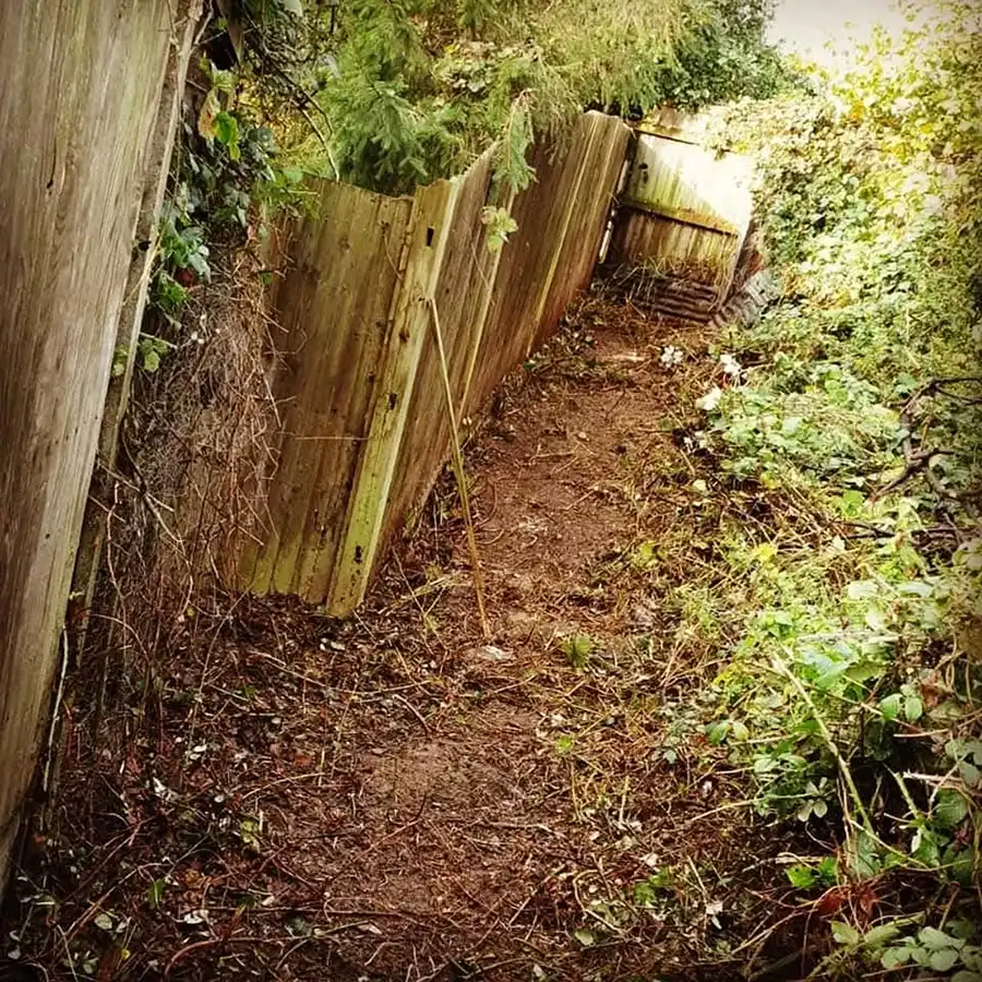 Wood alley way with fence on the left.