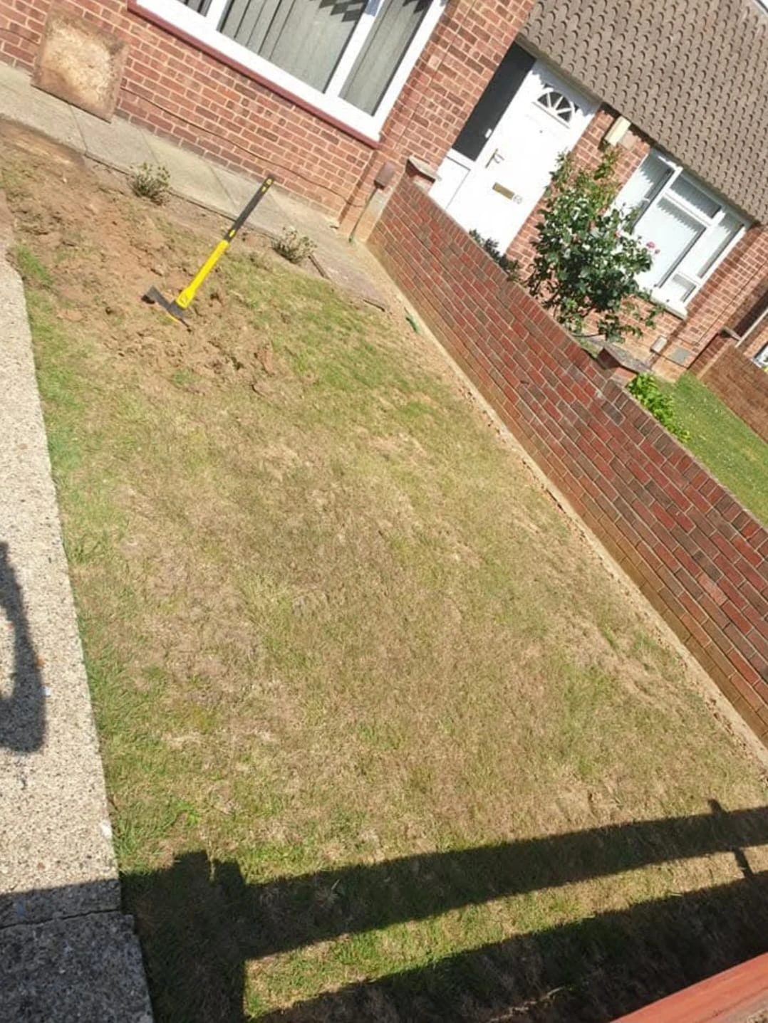 Garden with brown grass and fence.